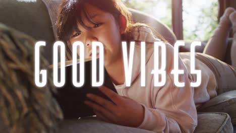 animation of good vibes text over asian girl using tablet