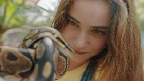 chica de la naturaleza sosteniendo una serpiente en el zoológico disfrutando de una excursión al santuario de vida silvestre estudiante divirtiéndose aprendiendo sobre reptiles 4k