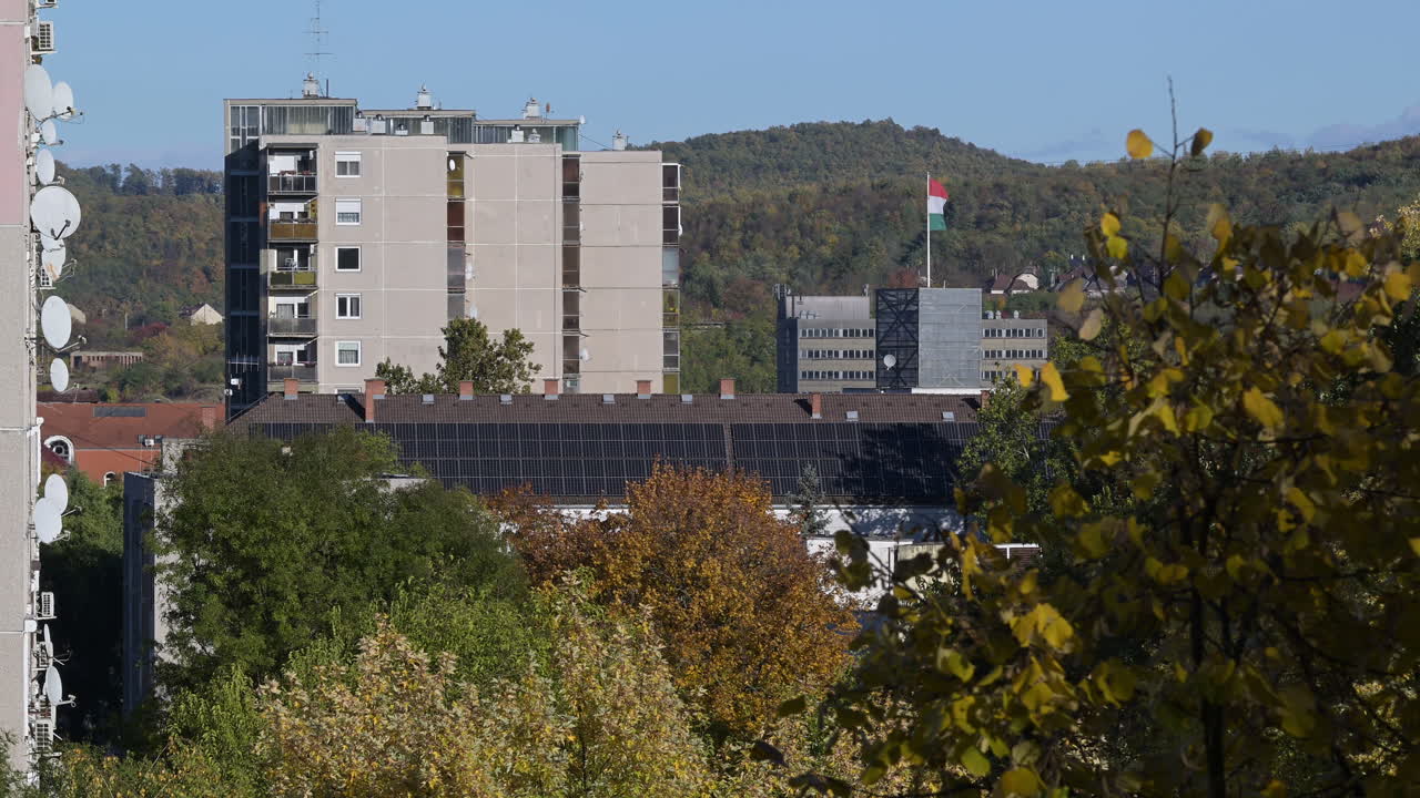 Apartment buildings with solar panels and forested hills