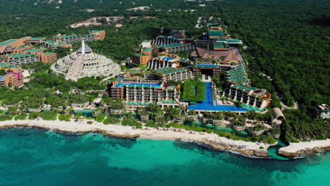 멕시코 킨타나로오 플라야 델 카르멘의 아름다운 xcaret arte 리조트와 열대 해변 주변을 높이 날고 있습니다.