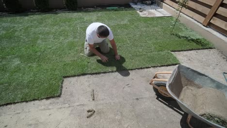 hombre colocando césped en el jardín del patio trasero para la instalación de césped y proyecto de jardinería, centrado en la mejora del hogar y el mantenimiento al aire libre para un césped fresco y verde en un patio residencial