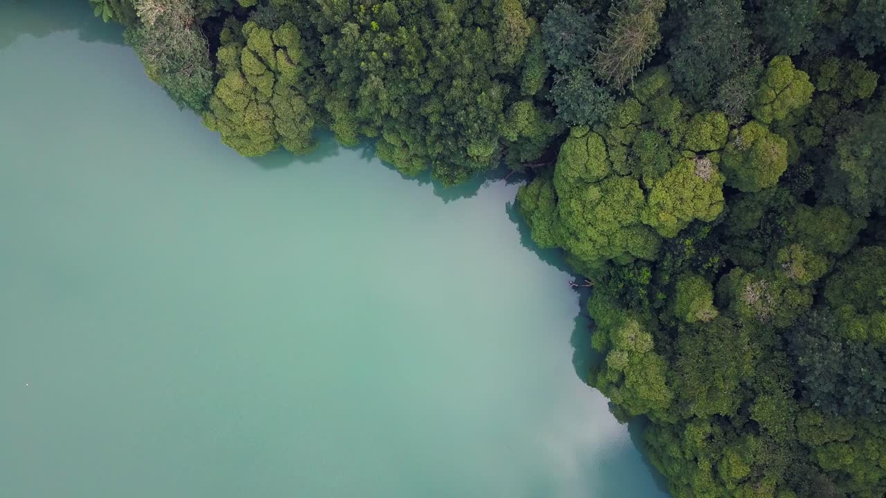 Aerial 4K drone video of a tropical hidden lake surrounded by trees in Sao Miguel, Azores islands