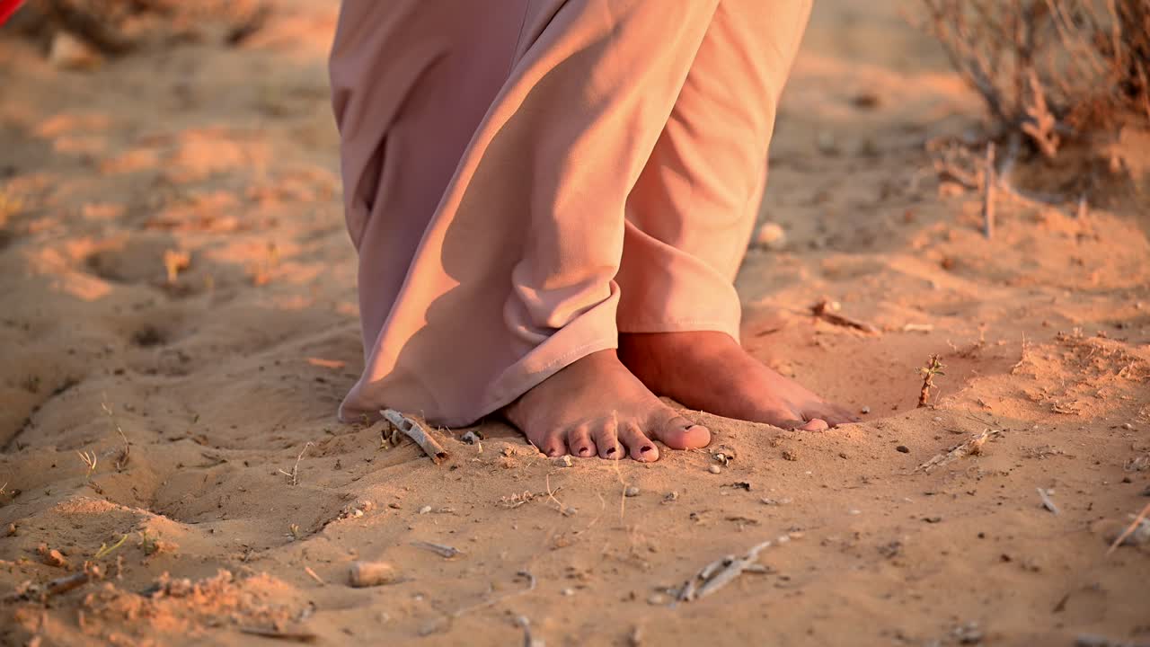 una dama árabe está descalza en las suaves arenas del desierto árabe
