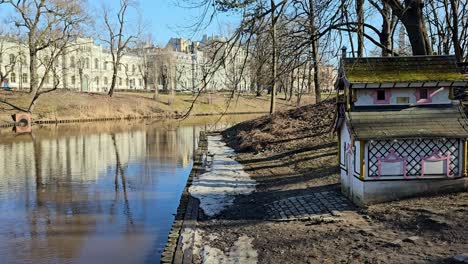 mały, biały dom z czerwonymi drzwiami i niebieskim dachem.