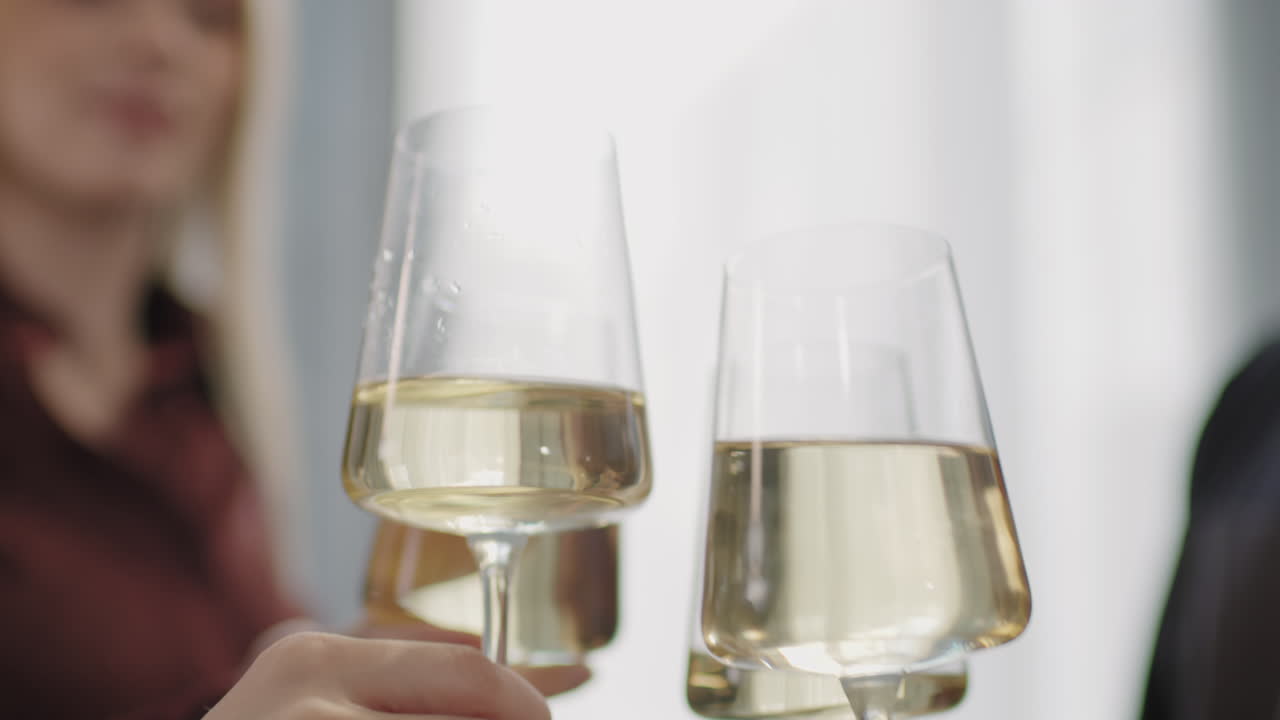 Unrecognizable People Toasting with White Wine