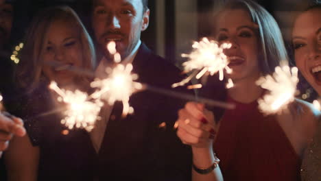 Sexy-group-of-friends-at-glamorous-party-lighting-sparklers