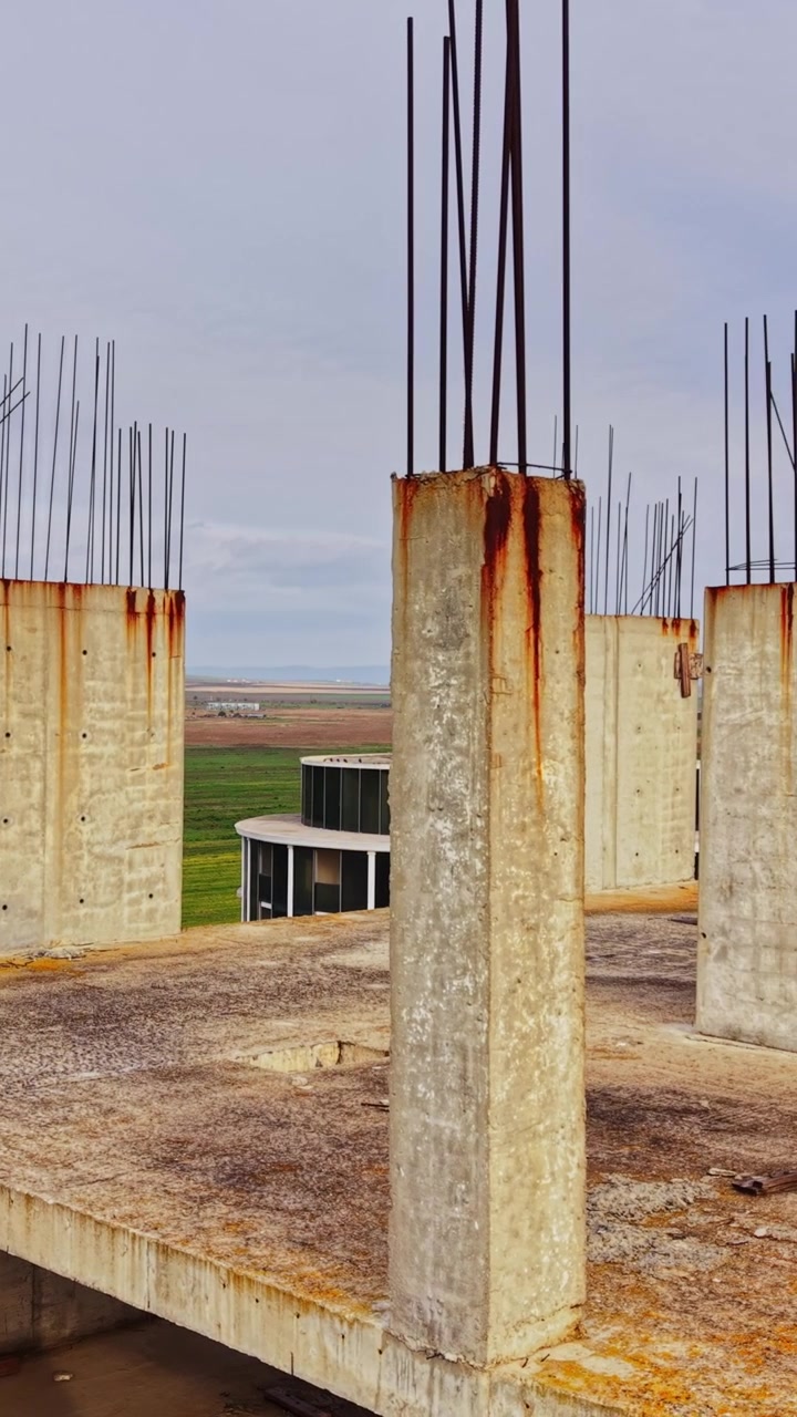 Cantiere edile con vista su un paesaggio verde con pilastri in cemento