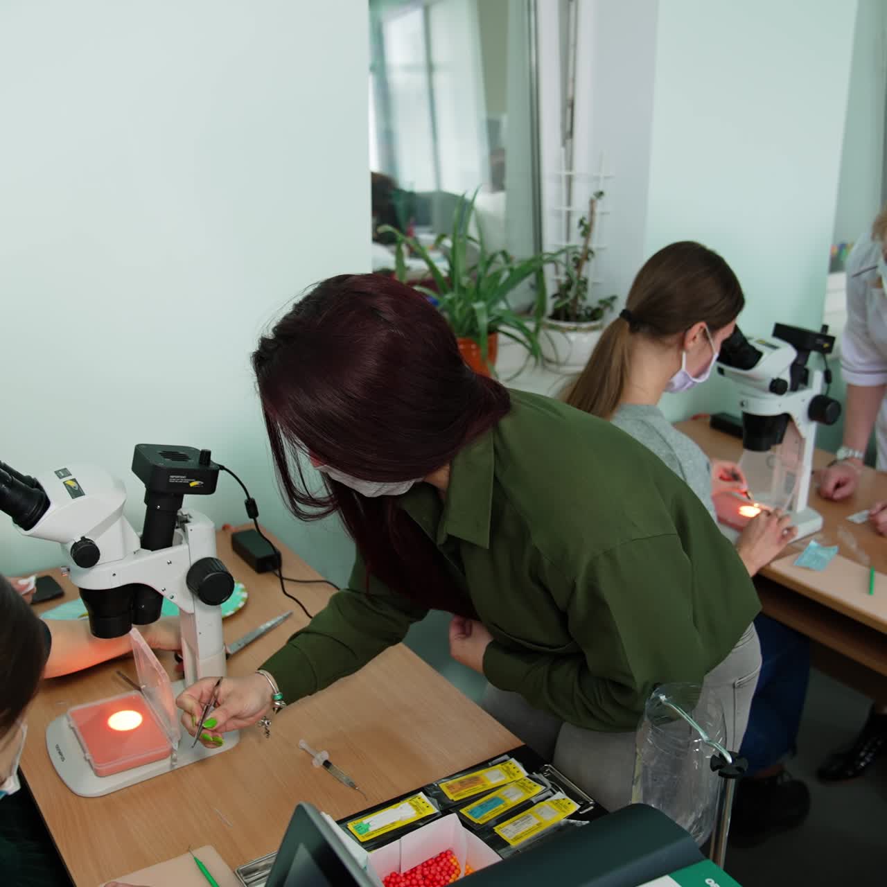 Future ophthalmologists having practical lessons. Students use medical instruments and microscope at the lesson