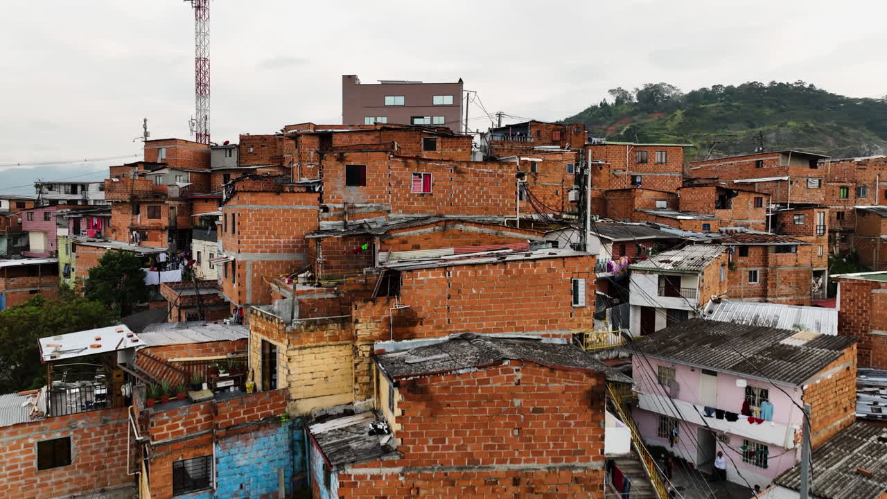 Aerial view low over slum homes in Comuna 13, cloudy day in Medell&iacute;n, Colombia