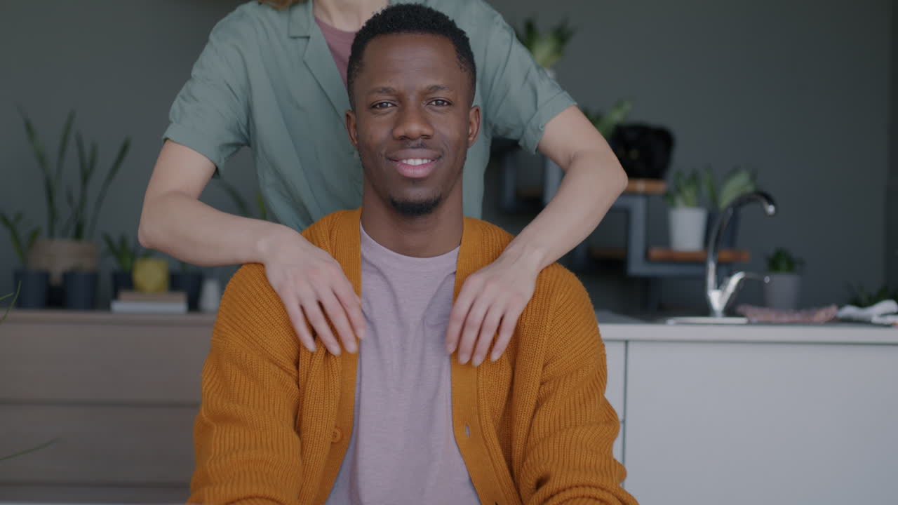 Happy Interracial Couple Hugging in Kitchen