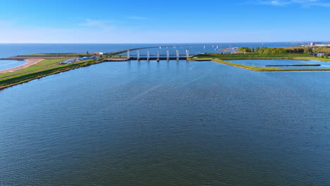 Netherlands sunset waterscape. Serene waters of the Netherlands reflect the vibrant colors of sunset, with bridges and sailboats enhancing the view