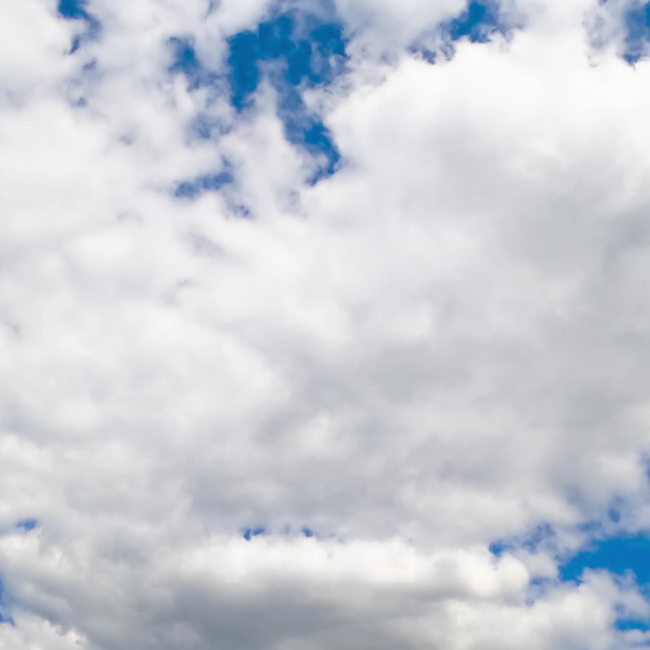 Bright azure skies hidden behind the soft white clouds. Cumulus clouds timelapse