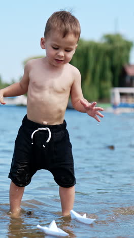 summer water pond playground. child playing on a river beach. vertical video