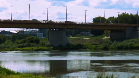 bridge time lapse of traffic passing by with blur motion from under the bridge with river and blue water