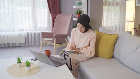 young muslim girl studying at home.