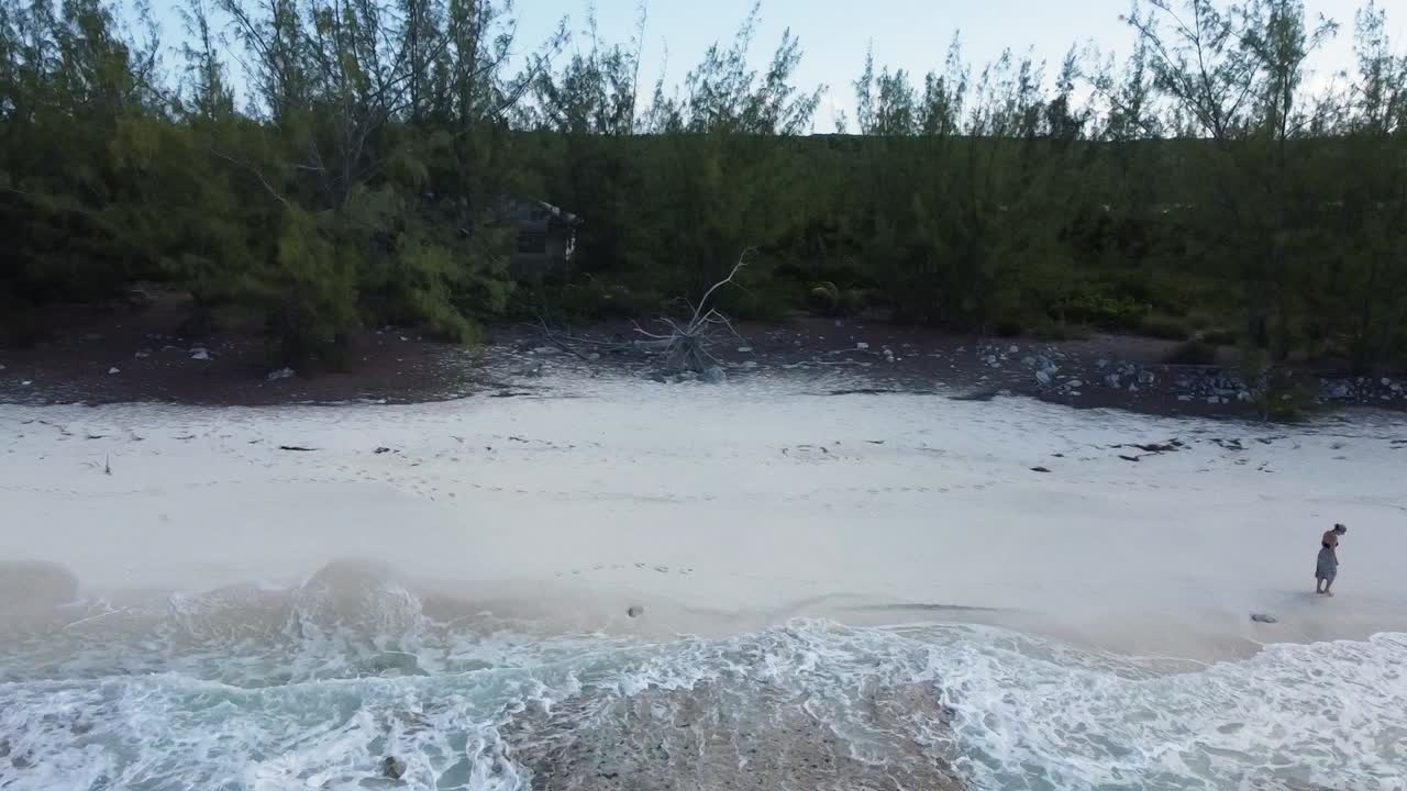 vista aérea de una mujer caminando por la playa en las bahamas
