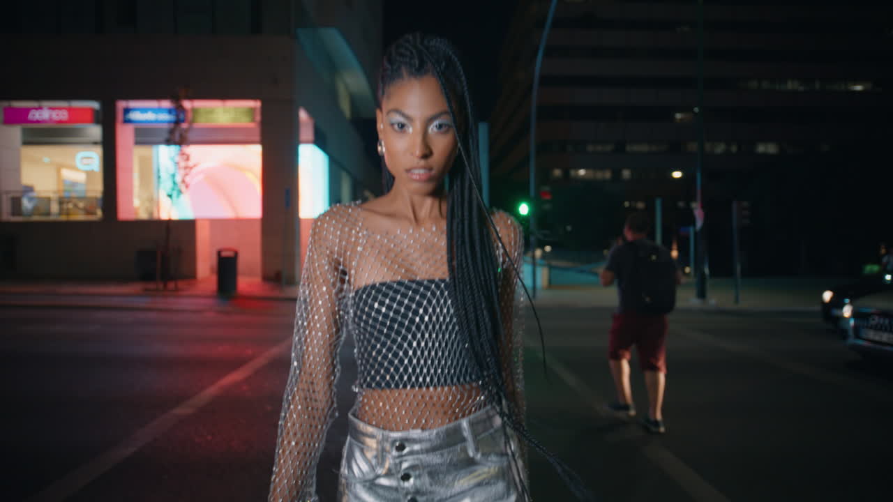 sexy fashionista caminando por la ciudad mirando la cámara en la calle ocupada de primer plano. chica posando