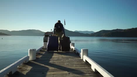 slowmo - male passenger with backpack, luggage and suitcase boarding walking on dock and boarding boat in the morning during sunrise