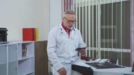 confident family therapist working online. doctor in white gown consulting people via internet using mobile phone in the office.