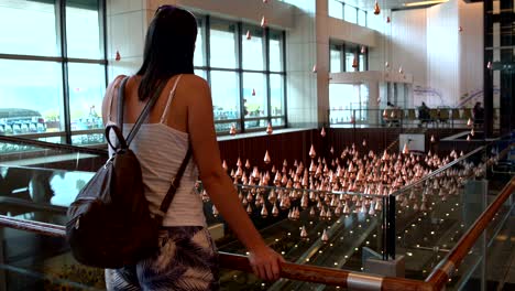 woman looking at kinetic rain in singapore airport