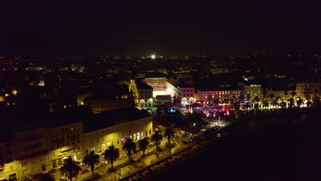 aerial view descending towards illuminated split cityscape nightlife and waterfront in croatia