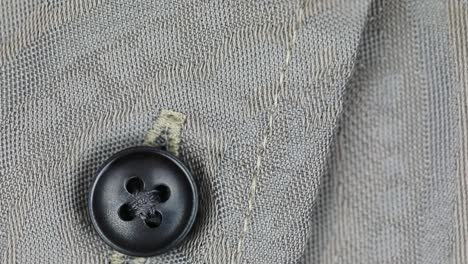 black button with four holes fastened on wool fabric