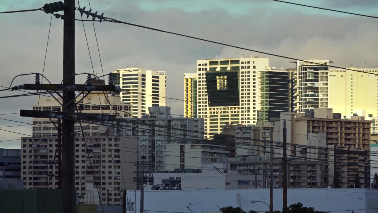 호놀룰루 하와이 빌딩은 전화와 전선을 통해 보입니다.