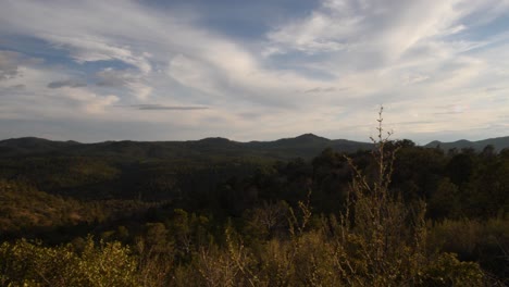 Pan-into-a-sun-flare-casting-a-ray-of-colors-as-the-sun-sets-over-thumbutte