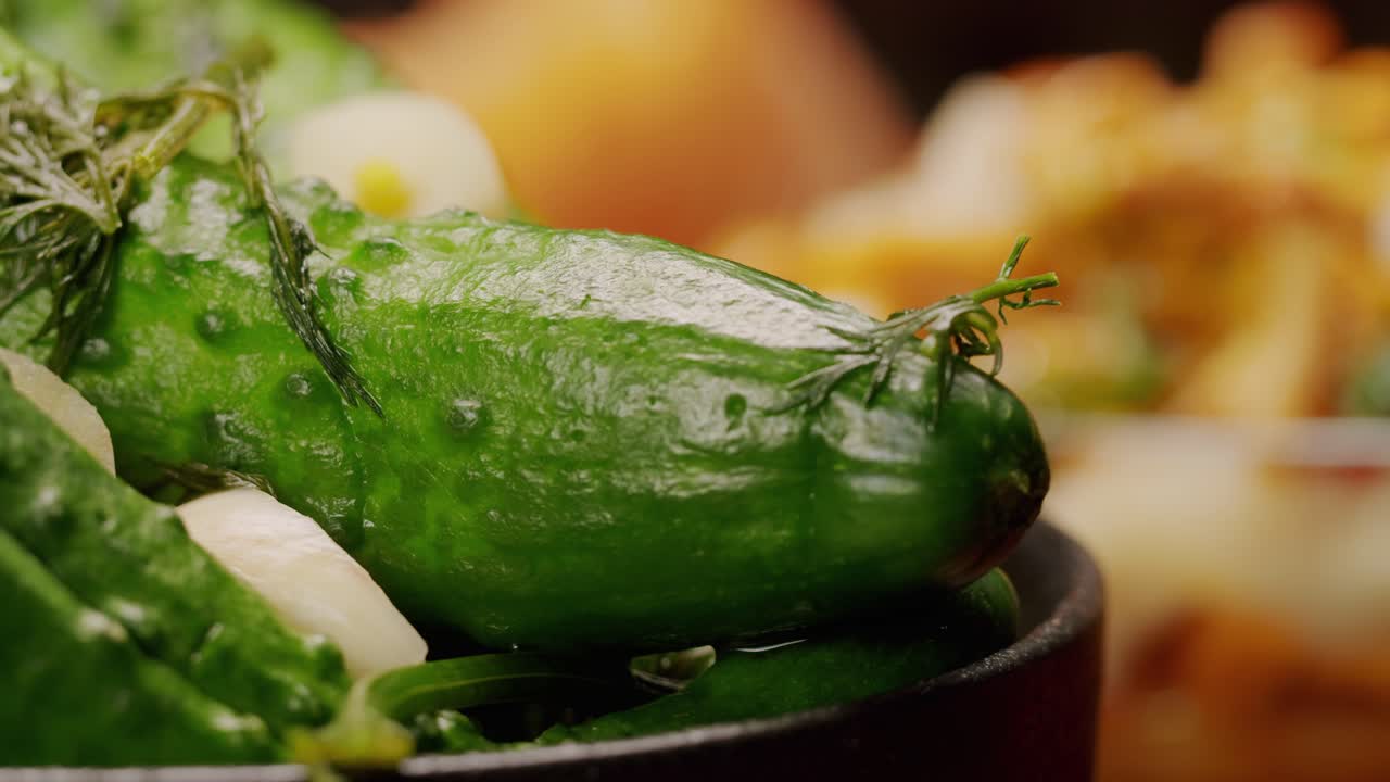 Close-up of fermented cucumbers with garlic and dill on plate. Preservation of vegetables in glass jars. Fermentation preserved cucumbers with spices. Russian cuisine.