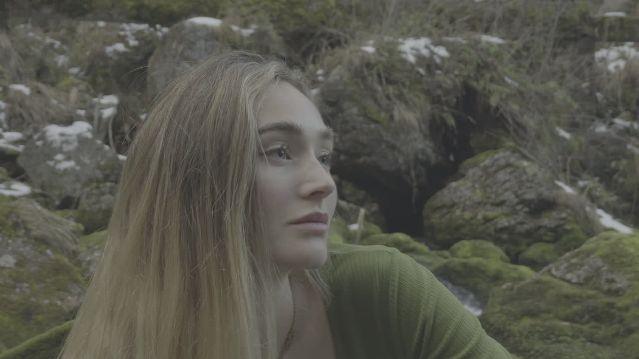 Woman in a Green Shirt by a Mountain Stream