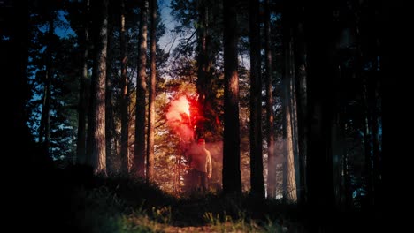 hombre agitando una torcha de señal roja en el bosque