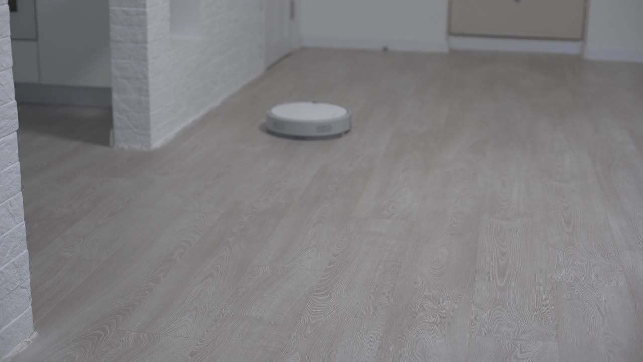 robot aspirador automático, máquina de piso limpio. robot aspirador limpieza automática en el hogar. aspirador robot realiza la limpieza automatizada del apartamento. hogar inteligente.