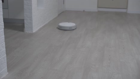 robot aspirador automático, máquina de piso limpio. robot aspirador limpieza automática en el hogar. aspirador robot realiza la limpieza automatizada del apartamento. hogar inteligente.