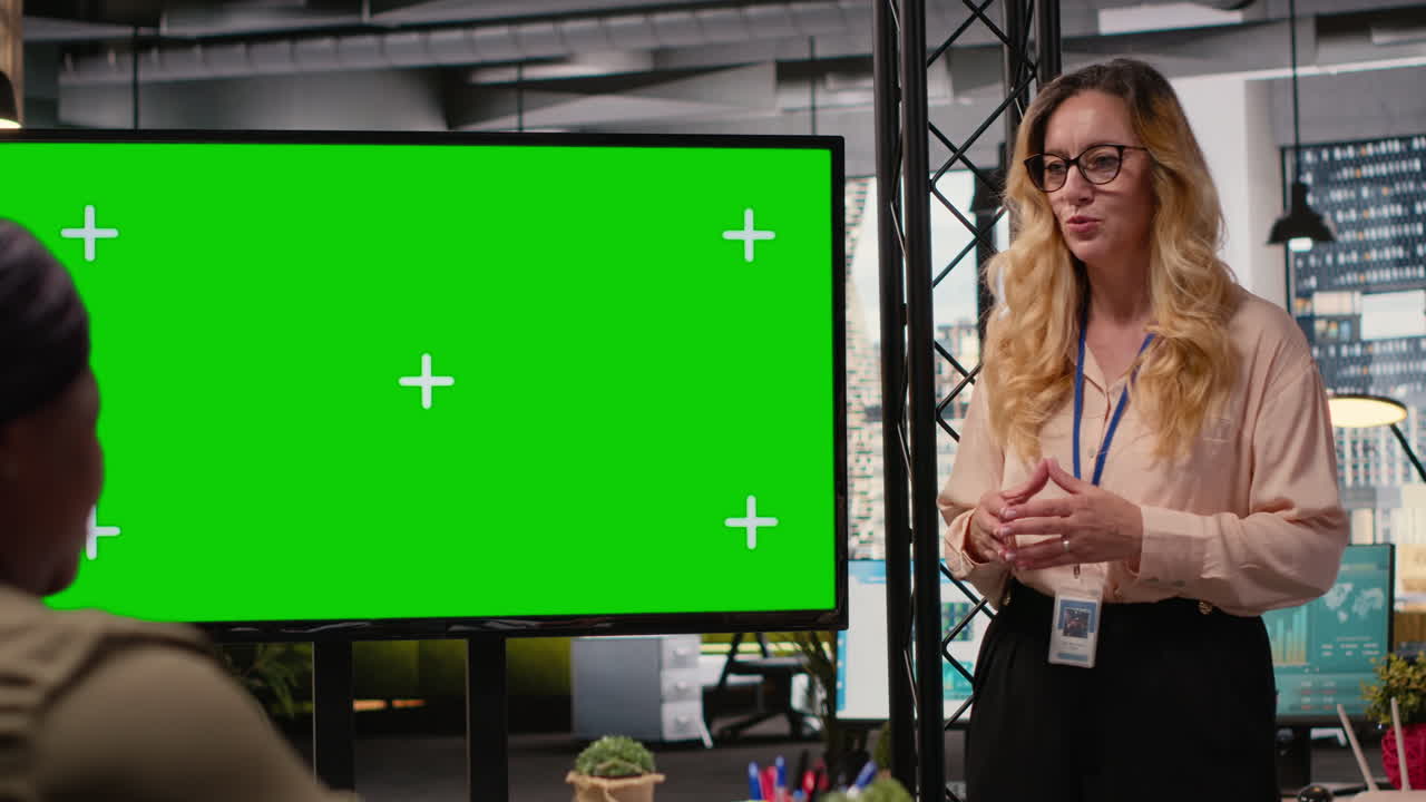 Manager and staff members using copy space on TV monitor during meeting