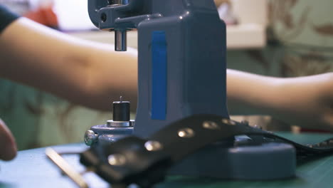 Professional-designer-changes-metal-nozzles-on-press-machine