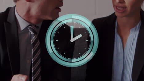 animation of neon ticking clock over caucasian businessman and businesswoman discussing at office