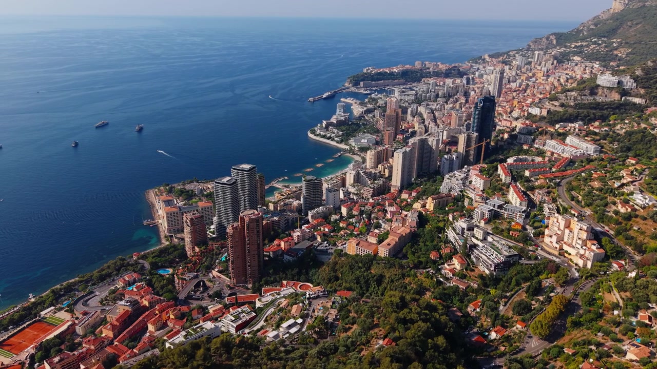 Veduta aerea della costa di Montecarlo con edifici cittadini, colline e mare blu