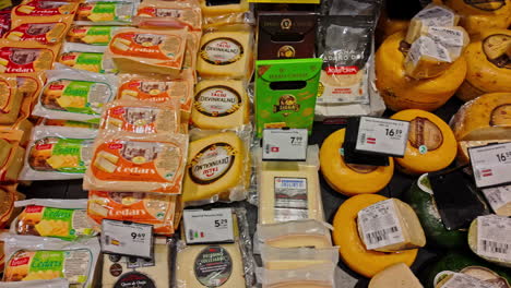 variety of cheeses on display in a supermarket