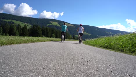 couple woman and man on electric eco bike cycling italy dolomites alps