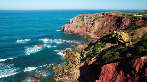 red sandstone cliffs of praia do amado near carrapateira in the algarve, portugal. aerial drone shot