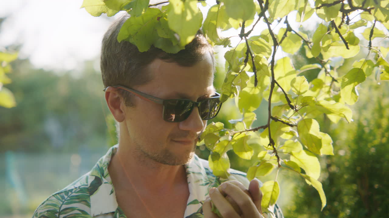 Man enjoying an apple in a garden