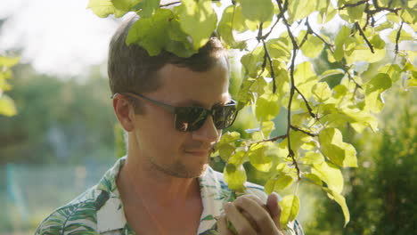 man enjoying an apple in a garden
