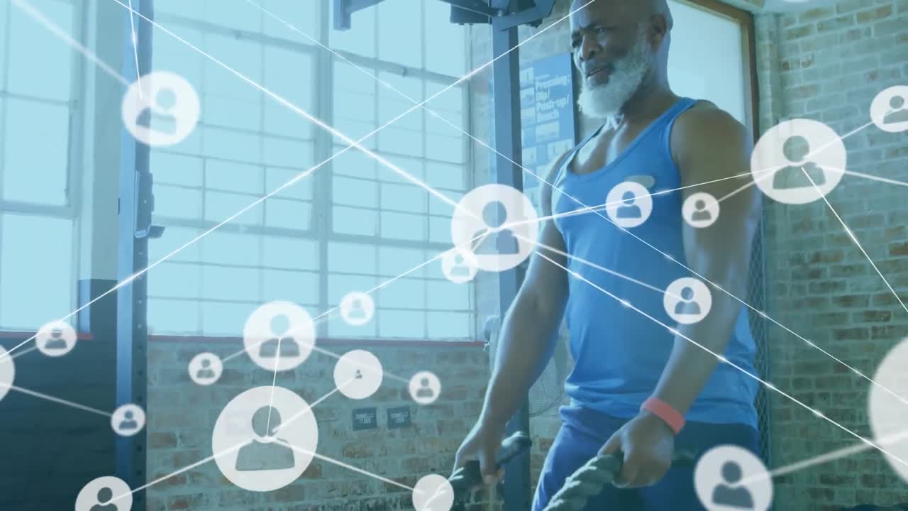 Animation of connected profile icons over african american senior man exercising with battle ropes