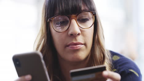 mujer que utiliza teléfono móvil y tarjeta de crédito para comprar en línea
