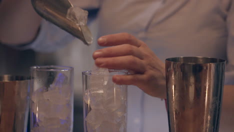 el camarero llena dos vasos altos con hielo