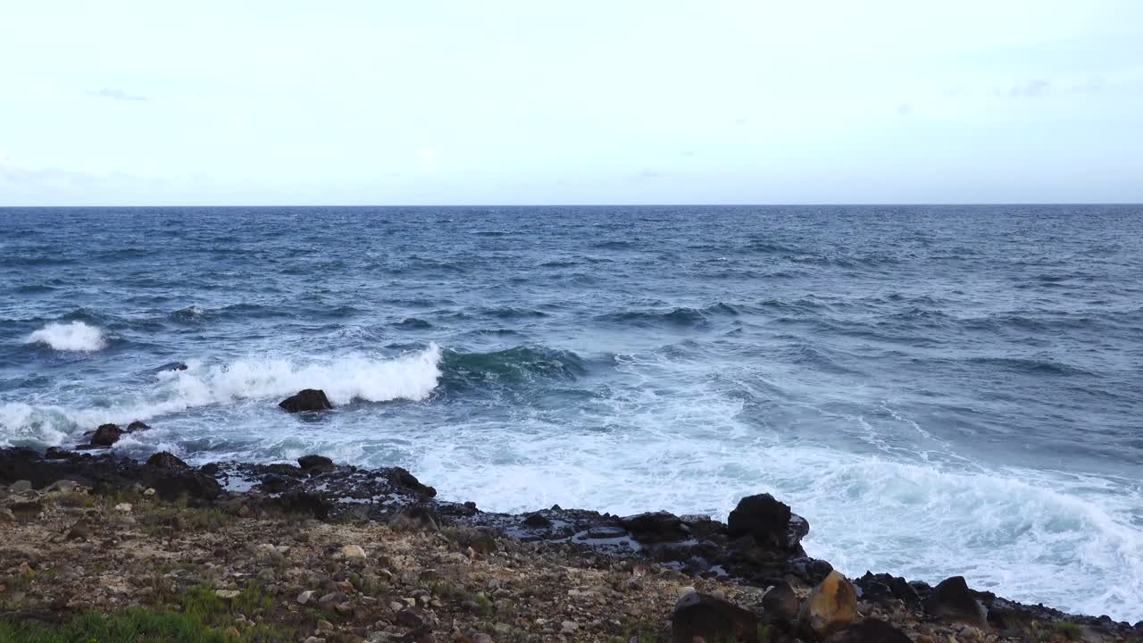 las olas del mar rompiendo en las rocas a lo largo de la orilla del mar lanzando spray en el aire