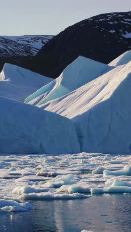 towering icebergs and icy waters against a mountainous backdrop