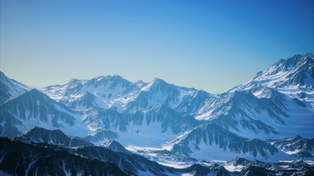 Majestic snow covered mountains under a radiant blue sky at dawn