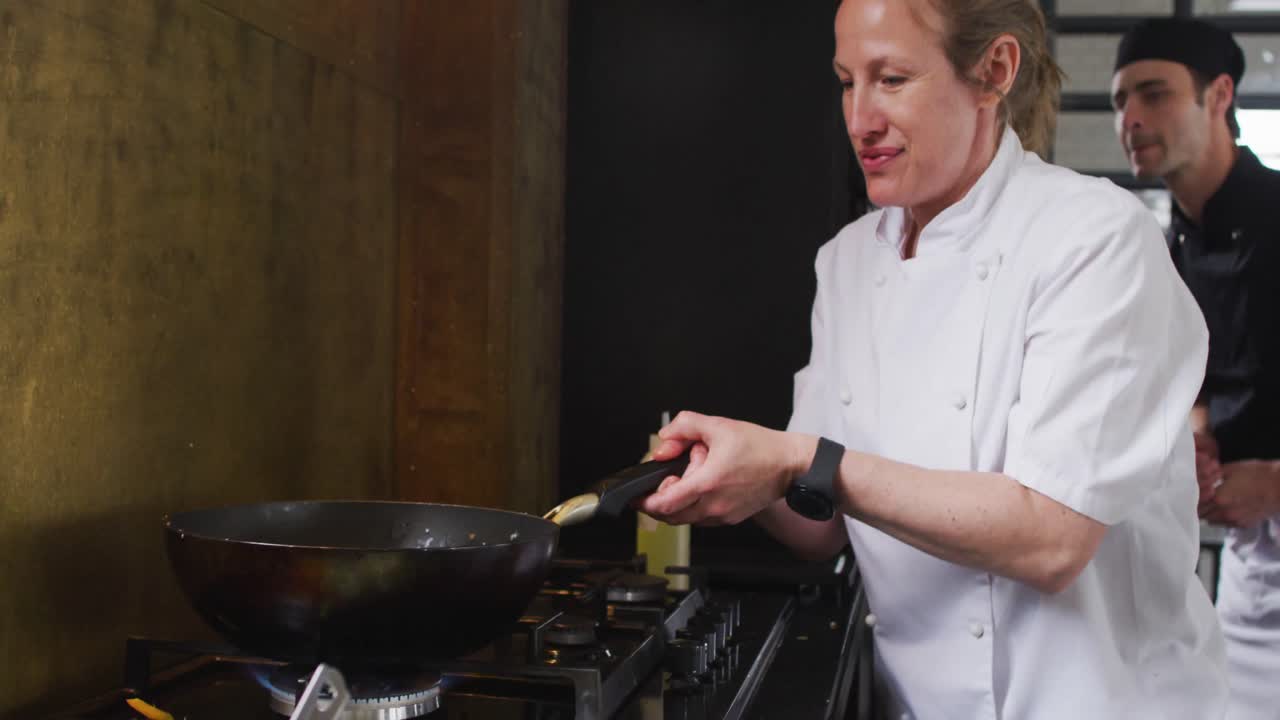 cocinera caucásica enseñando a un grupo diverso preparando platos y sonriendo