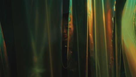 beautiful woman going through cellophane curtains in neon light